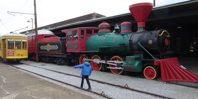 child walking on railroad track with colorful museum train engine at the Chattanooga's Choo Choo complex