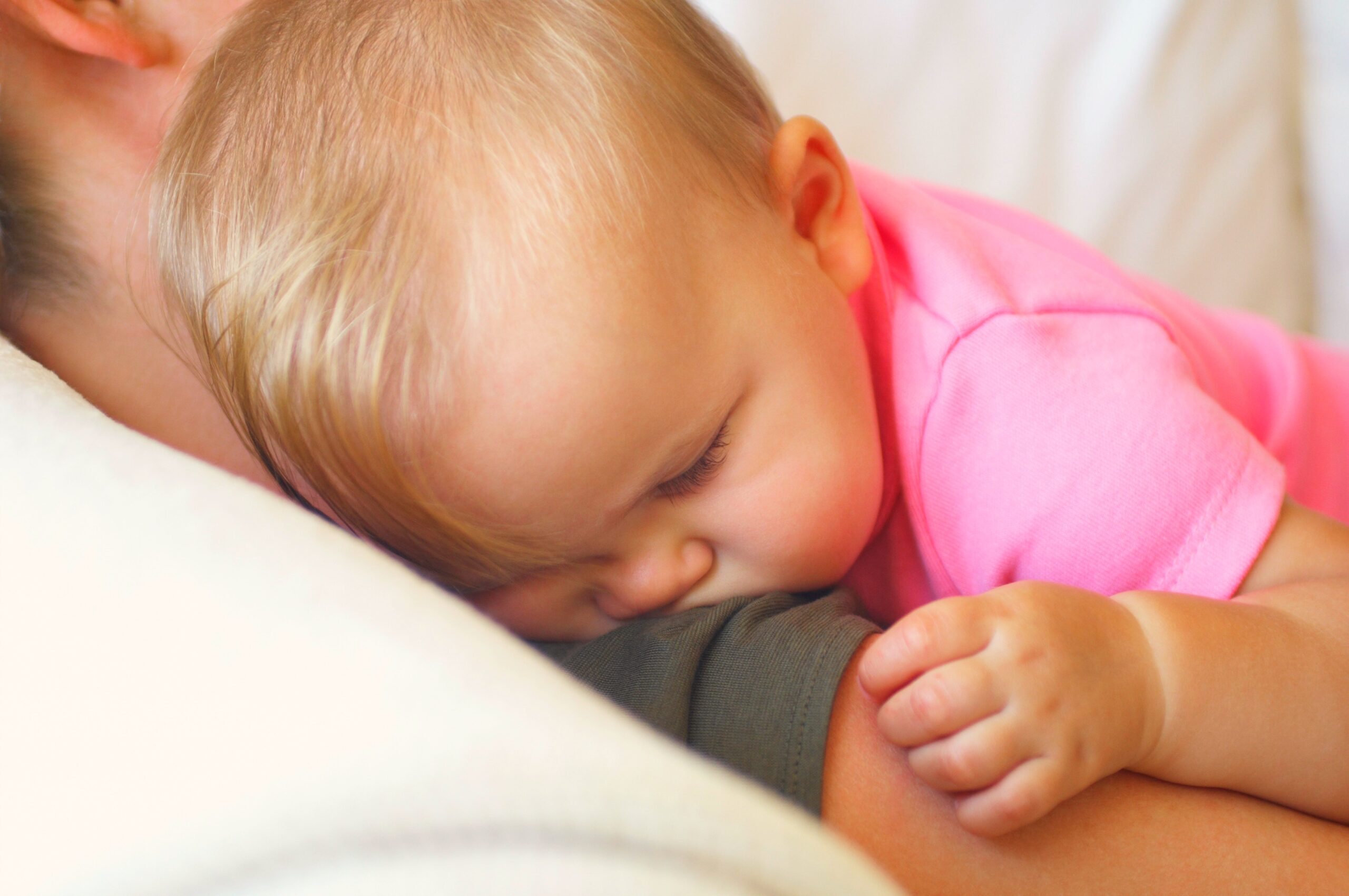 Baby sleeping on mother's shoulder.