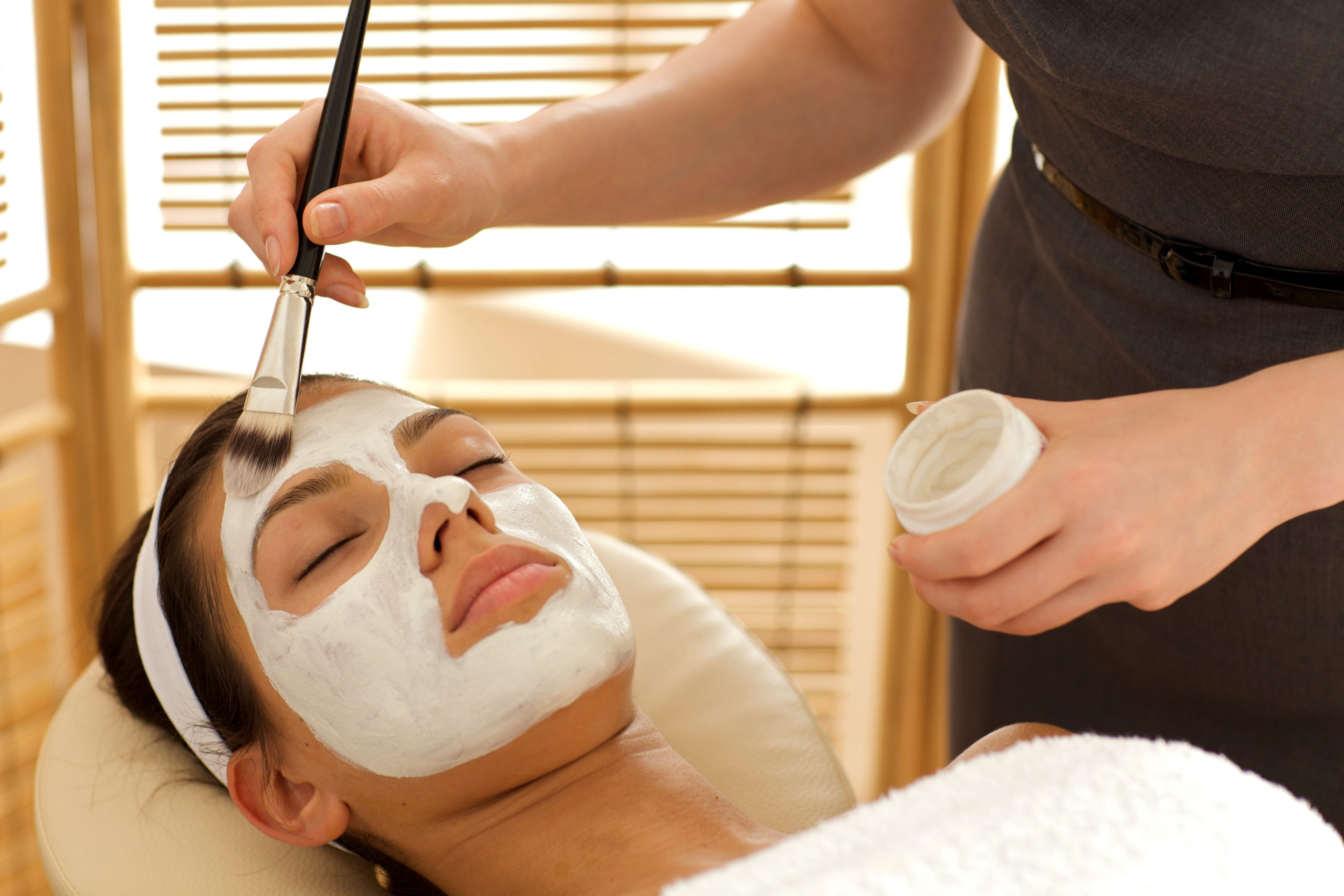 woman enjoying a painted on facial at a spa