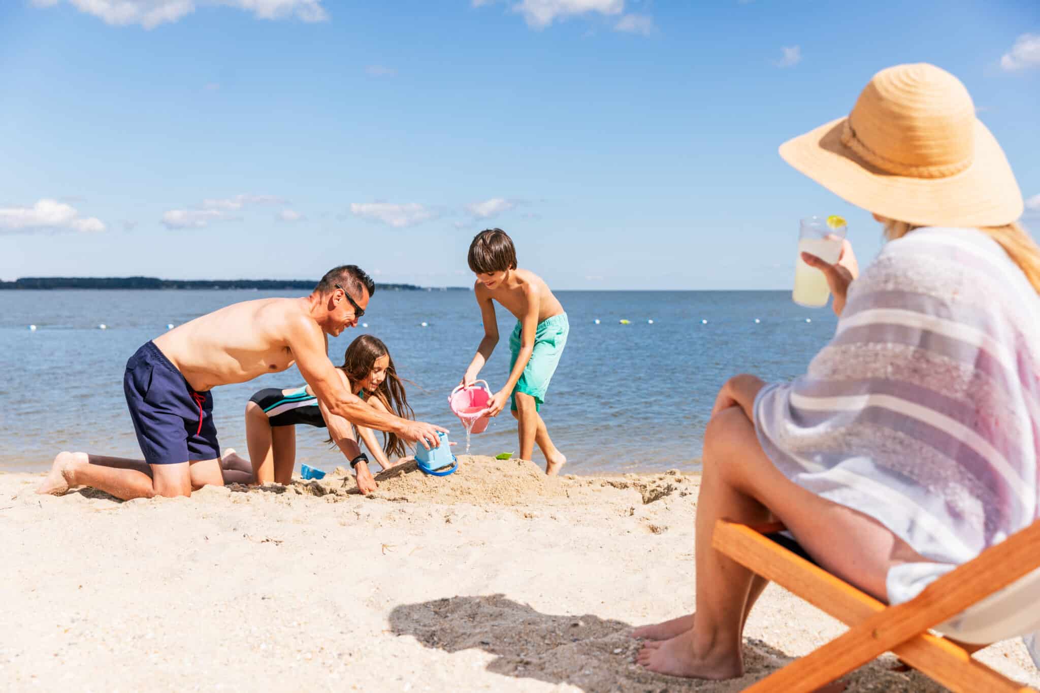 Family playing in the Yorktown Beach sand, a great beach near Virginia Beach VA