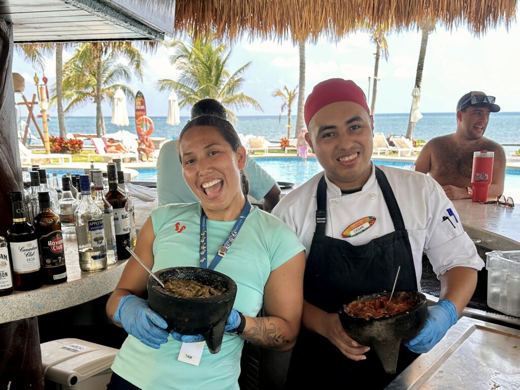 Woman and man hold bowls of salsa at the License to Chill bar in Cancun Mexico's Margaritaville resort.