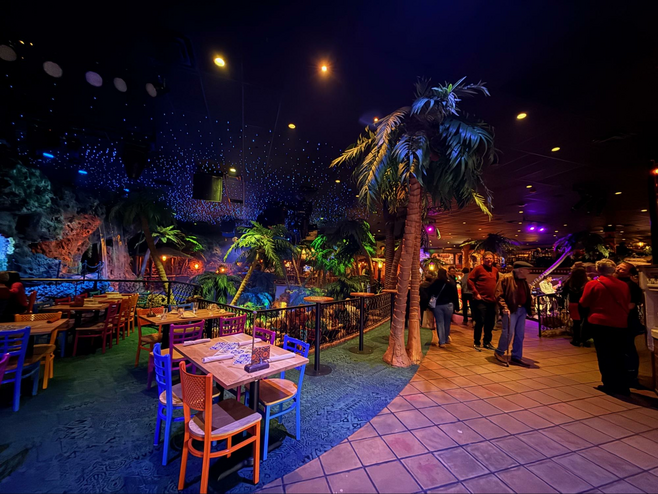 Tables and tropical decor inside Denver's Casa Bonita Mexican restaurant.