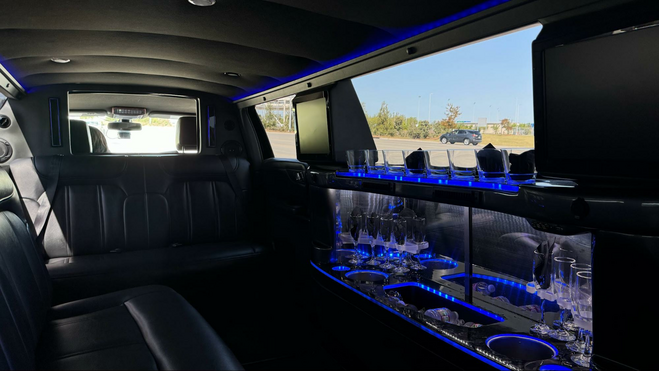 Leather limo sits and a limo bar with champagne glasses and blue LED lights.