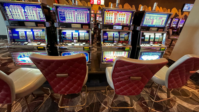 Four vibrant slot machines and four pleather chairs.