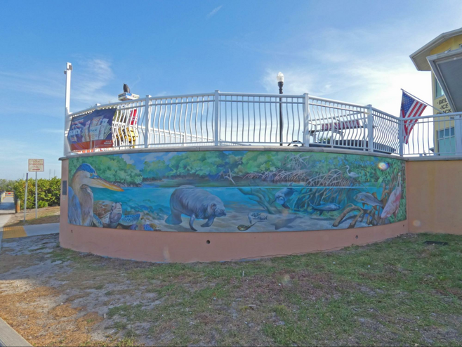 A circular mural of both underwater marine life and marshes above it.