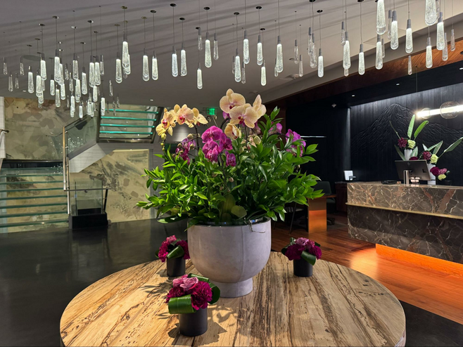 Hotel 1000 lobby with a table covered with brightly colored flowers in vases. The front desk also has florals.