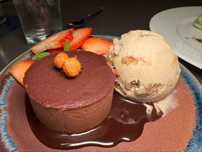 Chocolate dessert with ice cream and fresh fruit in a pool of chocolate sauce.