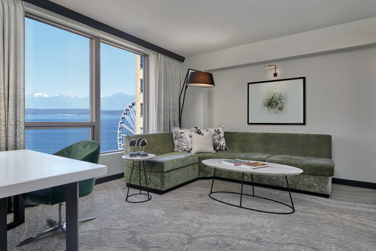 Sectional sofa with end table and coffee table. Window shows vies of downtown Seattle and the waterfront