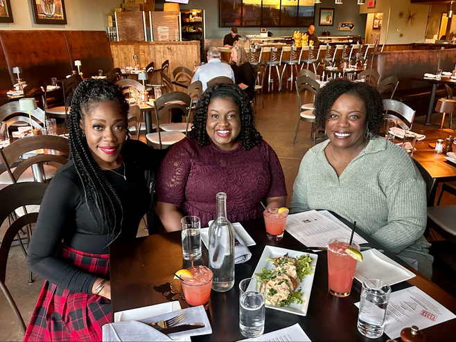 Group of friends enjoying food and conversation at a restaurant in Birmingham, Alabama.