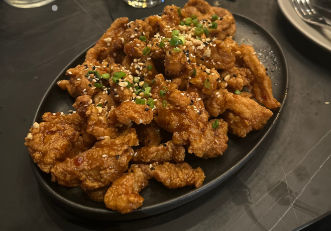 Crispy fried chicken served on a wooden platter at Dread River Distilling Co. in Birmingham, Alabama.