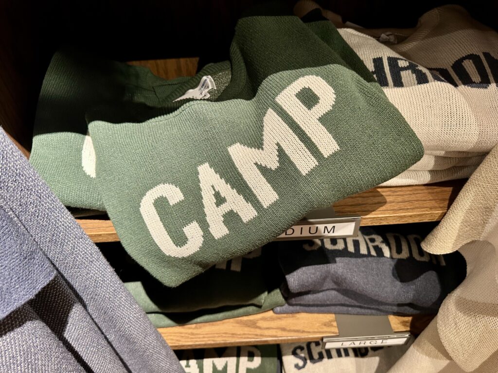 Green CAMP sweater on a shelf.
