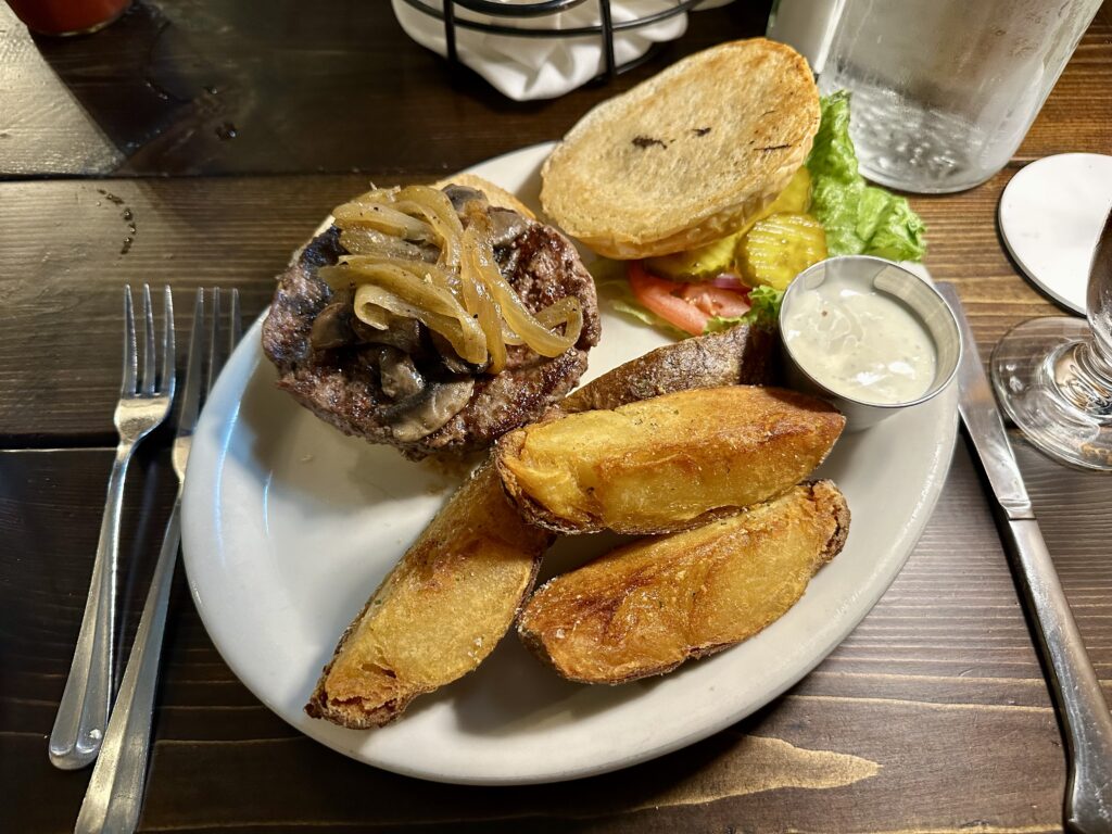 Burger with mushrooms, onions and crisp potato wedges.