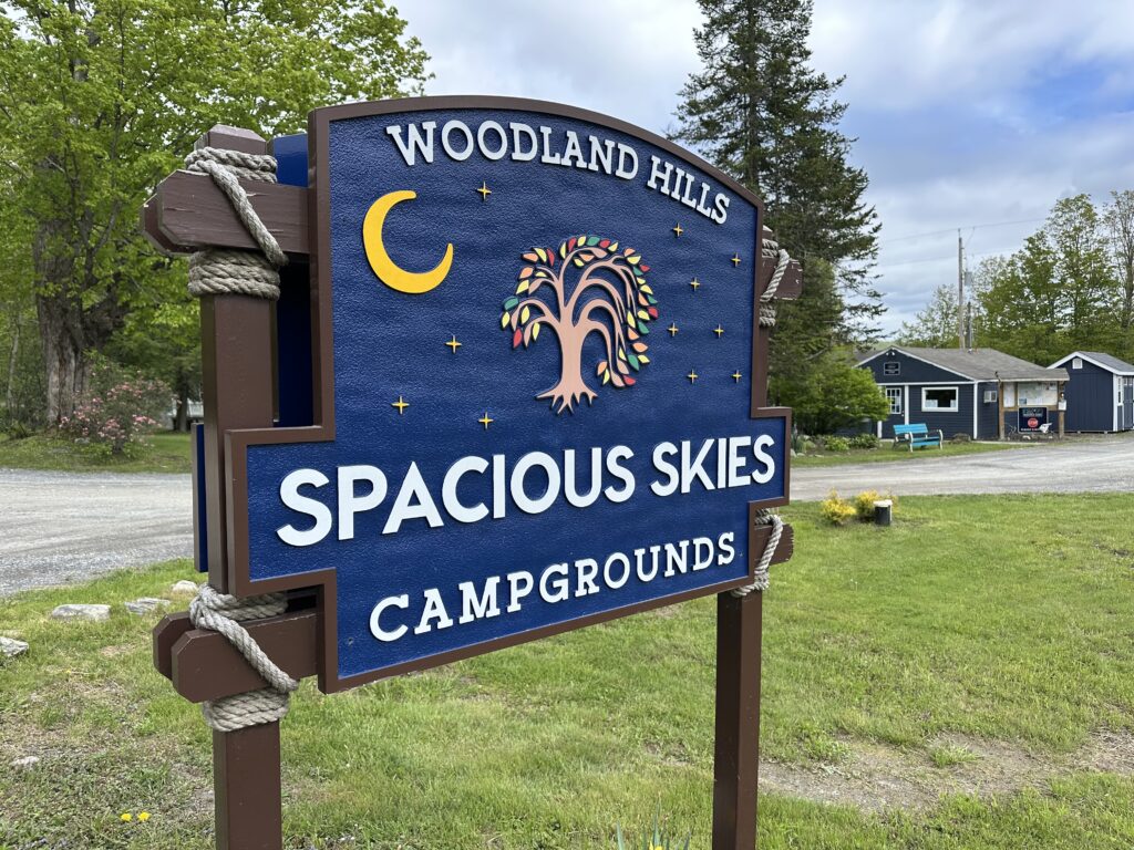 Colorful welcome sign at Spacious Skies Woodland Hills Campground.