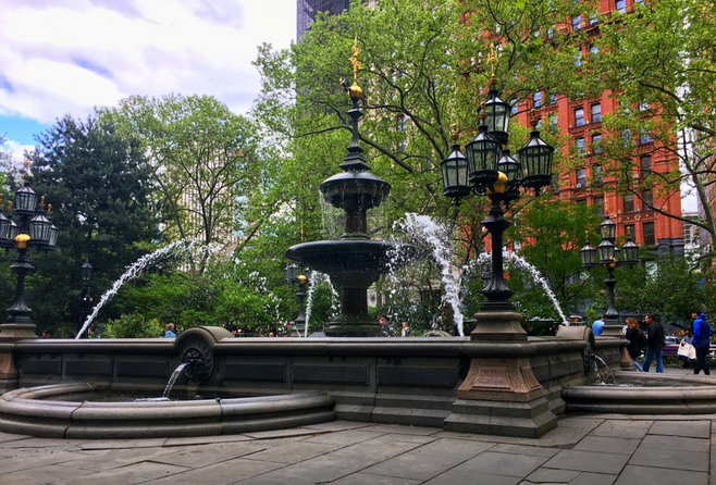 Fountains Running In City Hall Park, Manhattan and green trees surrounding it