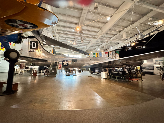 Silver colored plane with two small planes in a display