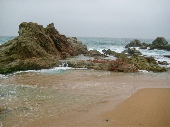 Cliffs and pounding waves along a sandy beach