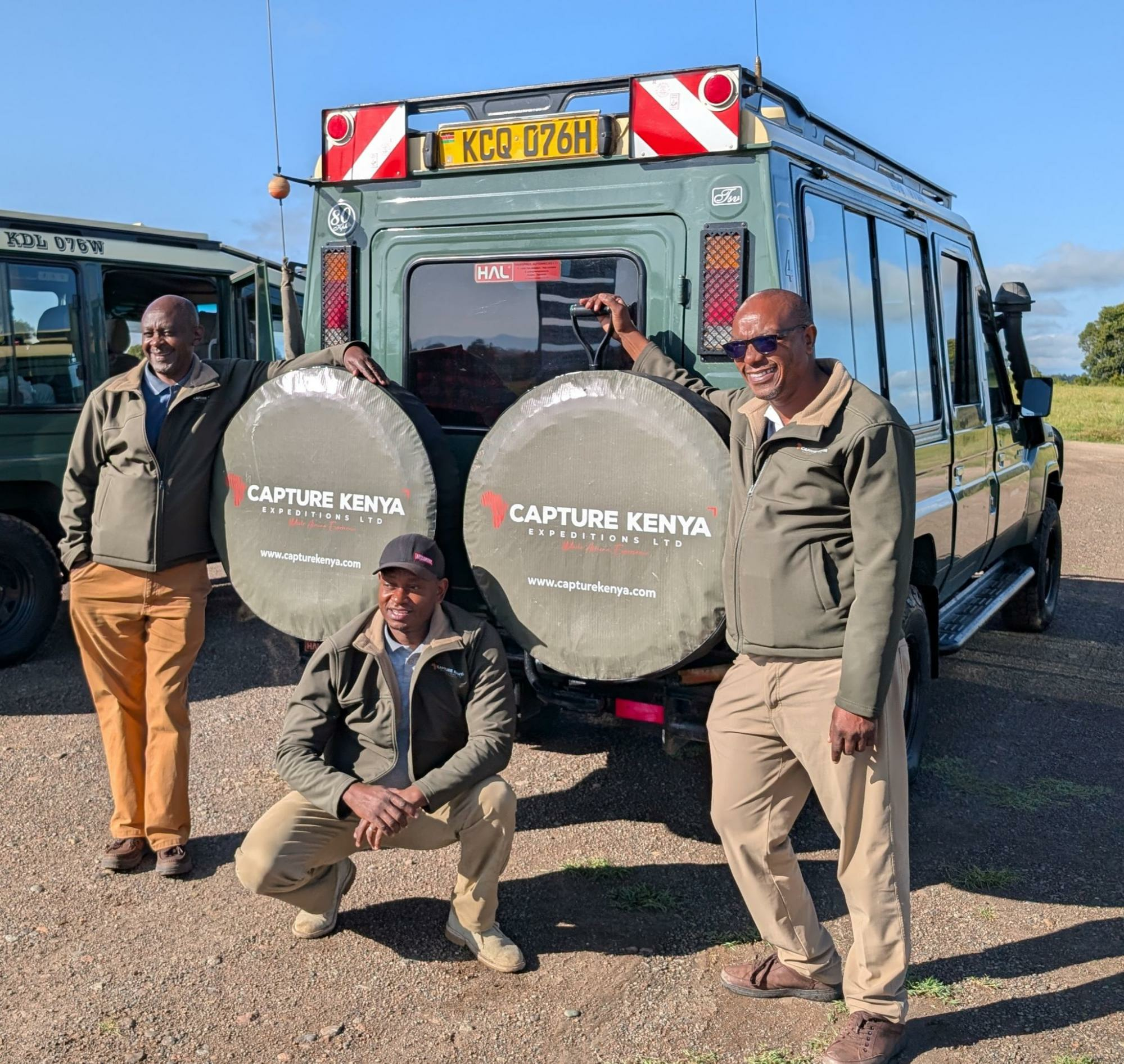 Capture Kenya tour guides pose by one of the company's vehicles.