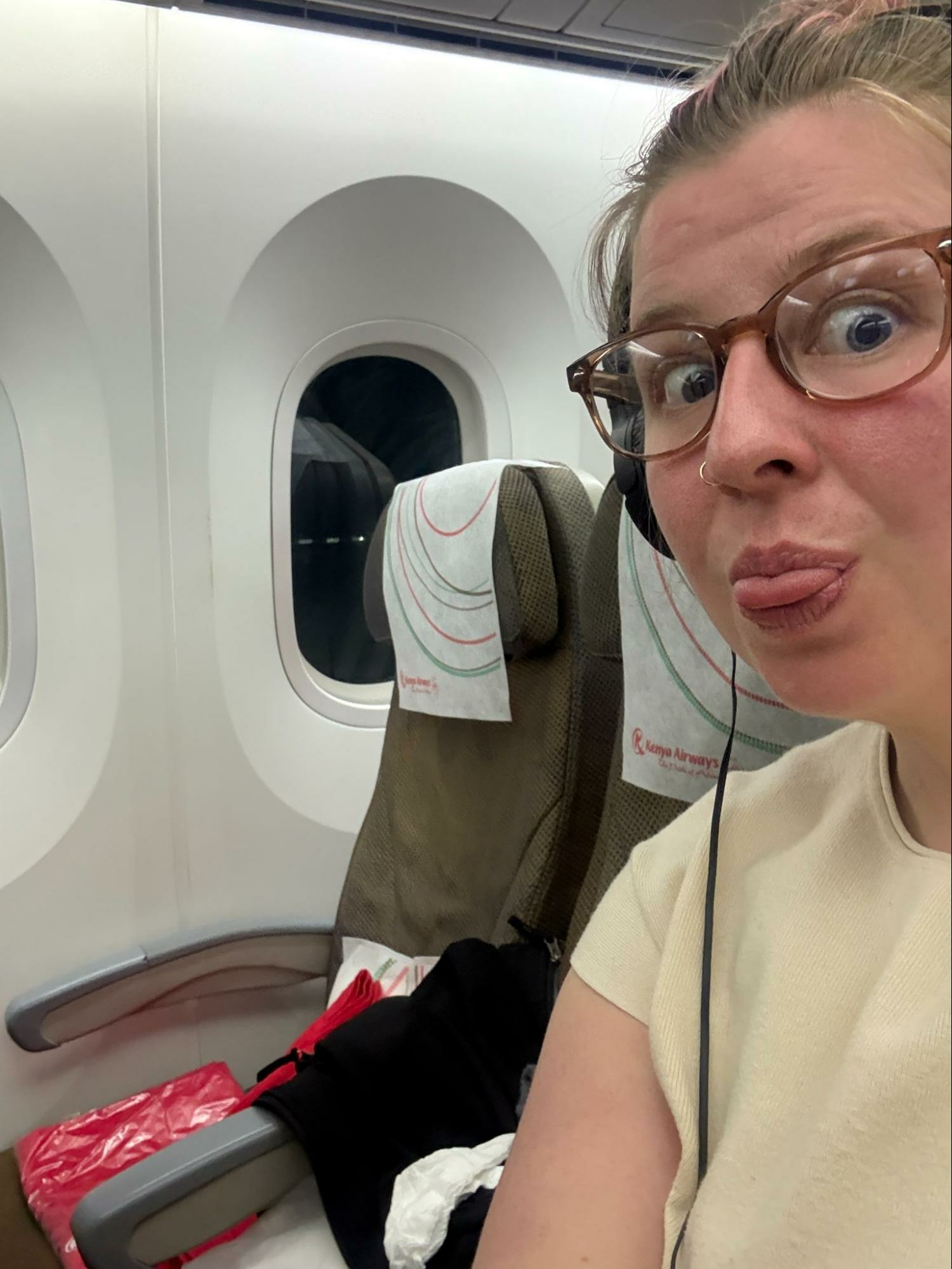 Woman takes a selfie to show she has 3 seats to herself in economy class on a long flight