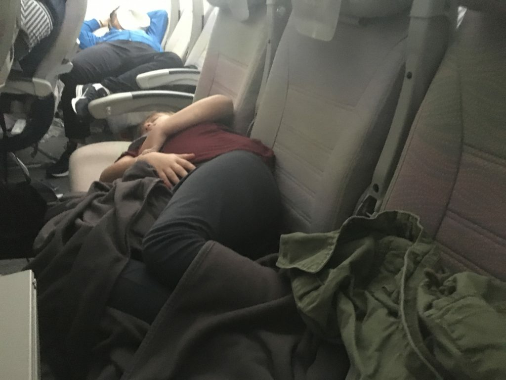 tween sleeping on a plane across three seats