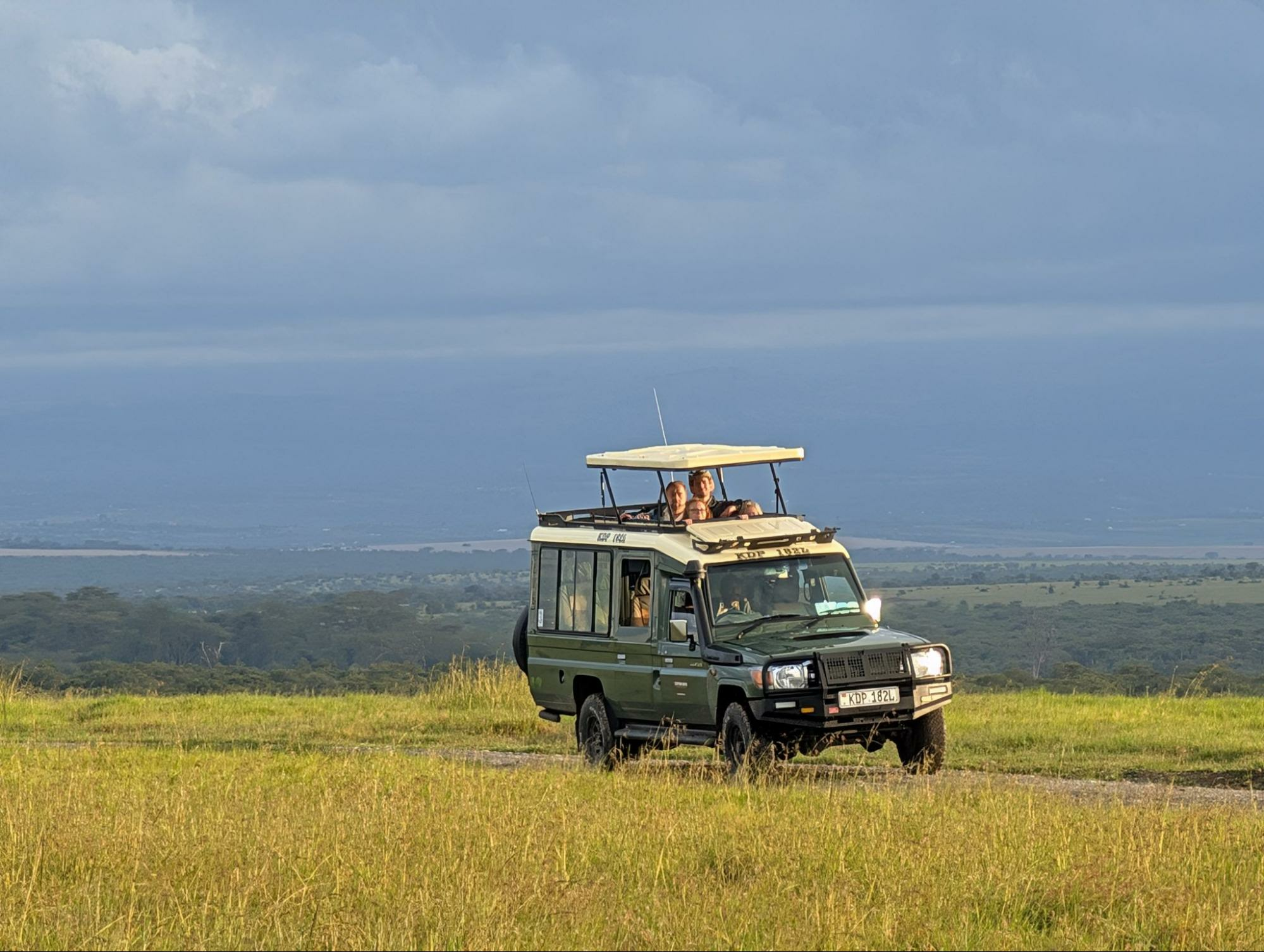 Capture Kenya Expeditions truck with the top up and guests looking for animals in Kenya
