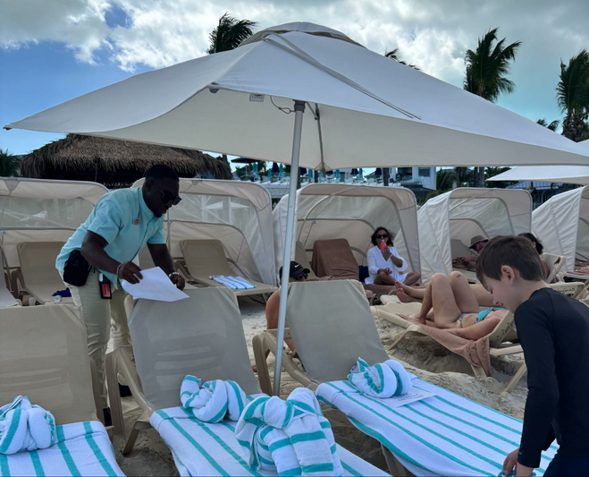 A Beaches Resort butler puts the finishing touches on reserved ocean-side beach chairs complete with towel animals.