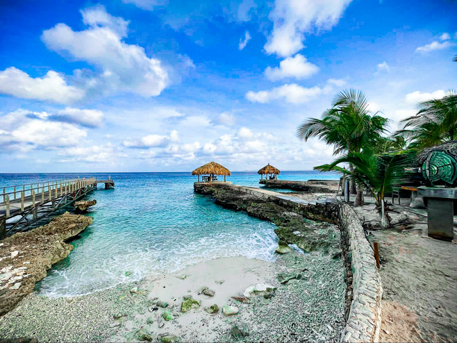 Vibrant blue sky and water with Waterfront jetty and palm trees