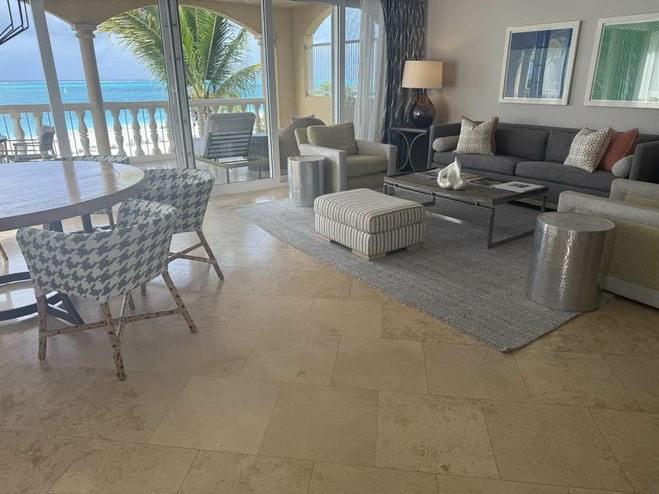 Comfortable Living Room with couch, coffee table and ottoman looking out over the balcony with the ocean in the background