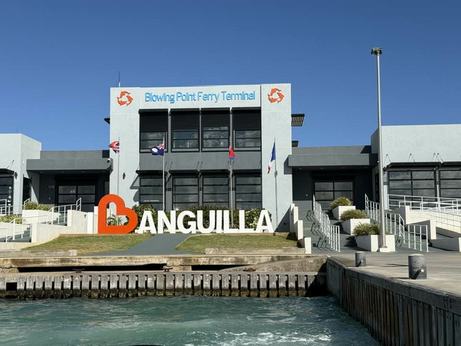 Ferry terminal sign in front of a modern building with ferry dock.