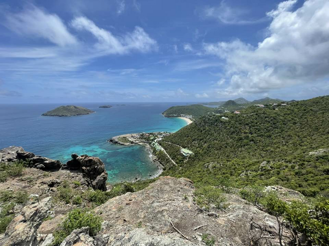 View of the water from a mountain-side observation point with two smaller islands in the distance.