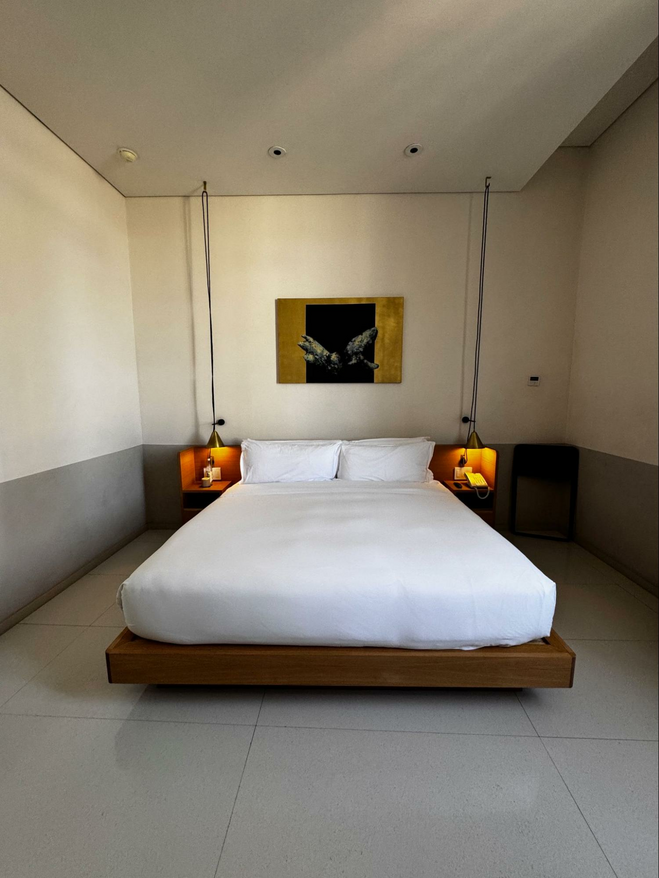 Bed surrounded by modern warm lighting at Umbral hotel.
