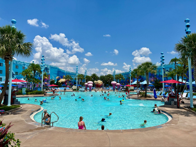 A large pool filled with swimmers of all ages at Disney's Art of Animation Resort.