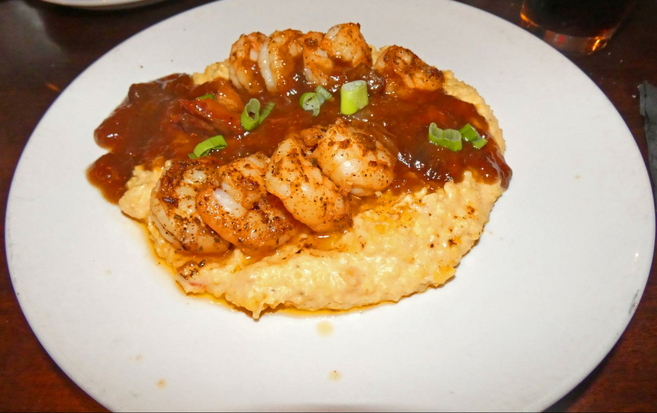 White plate with shrimp and grits.