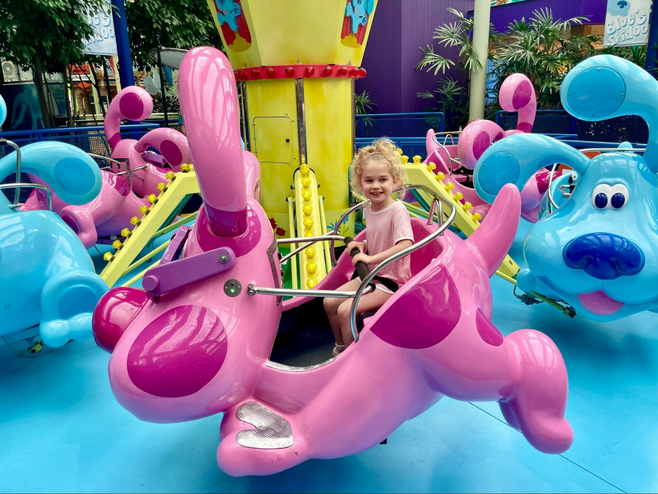 Girl rides a kiddie ride at Nickelodeon Universe at Mall of America