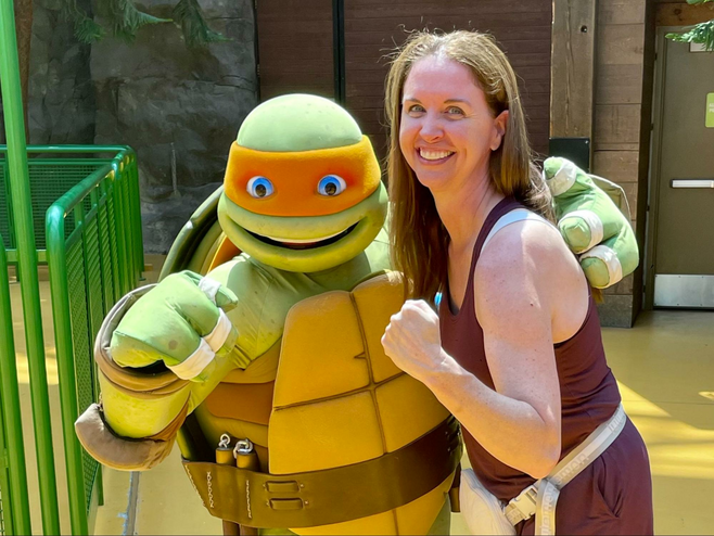 Woman poses with a Teenage Mutant Ninja Turtle character at Nickelodeon Universe at Mall of America