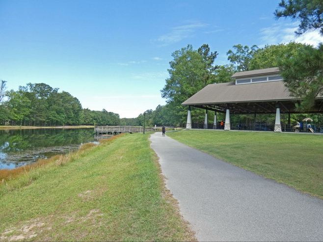 Walkway by lake and shelter at Tom Triplett Park.