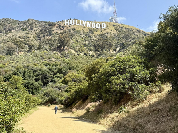 Man walking on trail up towards Hollywood Sign.