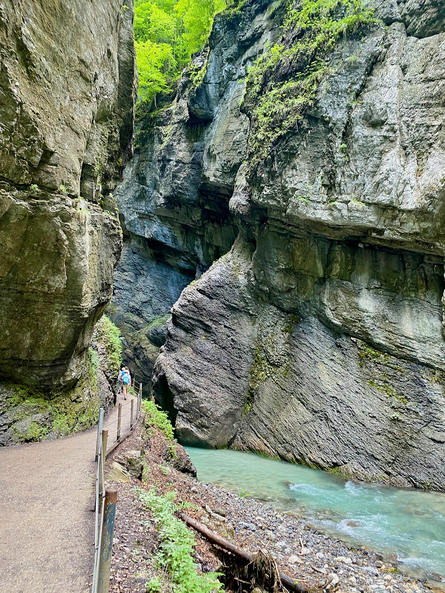 Hiker walk along path at bottom of narrow gorge