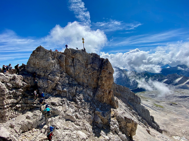 Hikers climbing to the top of mountain peak.