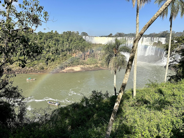 Water falls flowing into river from the shore.