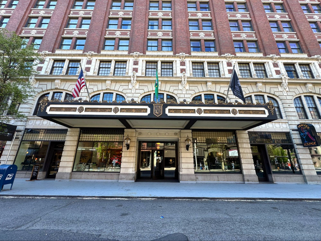 The front entrance with ornate overhand with flags. Large picture windows with displays