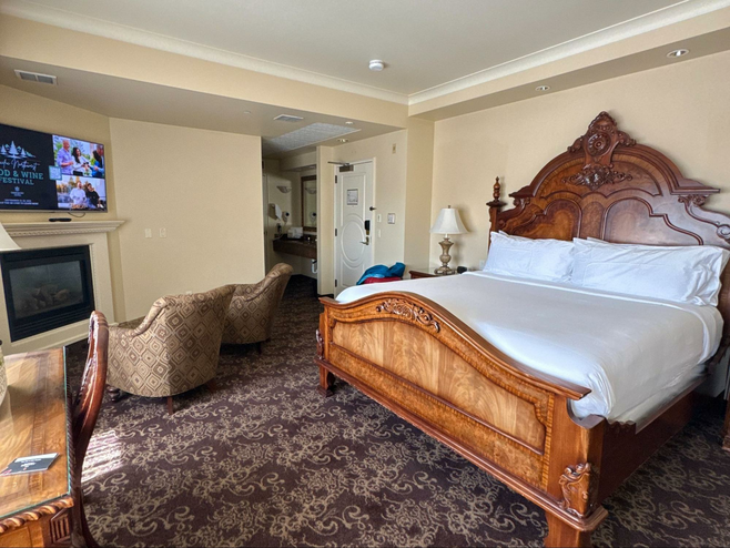 Room with large antique bed and vintage looking carpet.