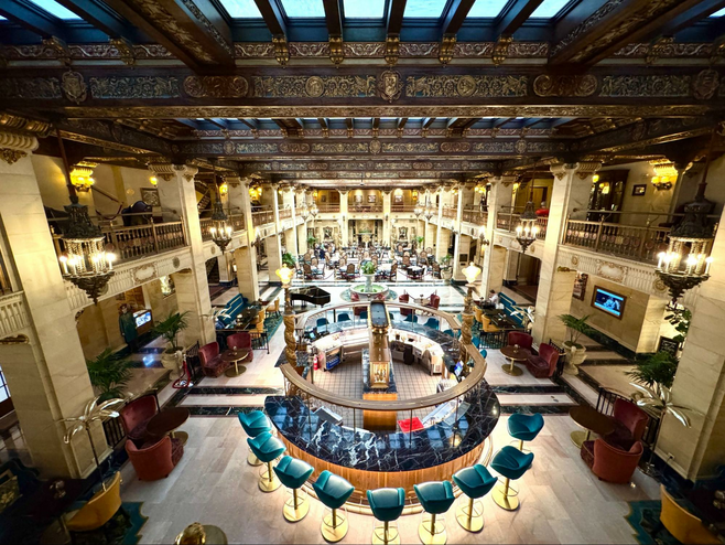 Round bar with turquoise leather bar stools surrounded by intimate seating areas.