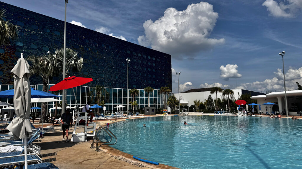 Pool and pool deck at Stella Nova resort with building in the background.