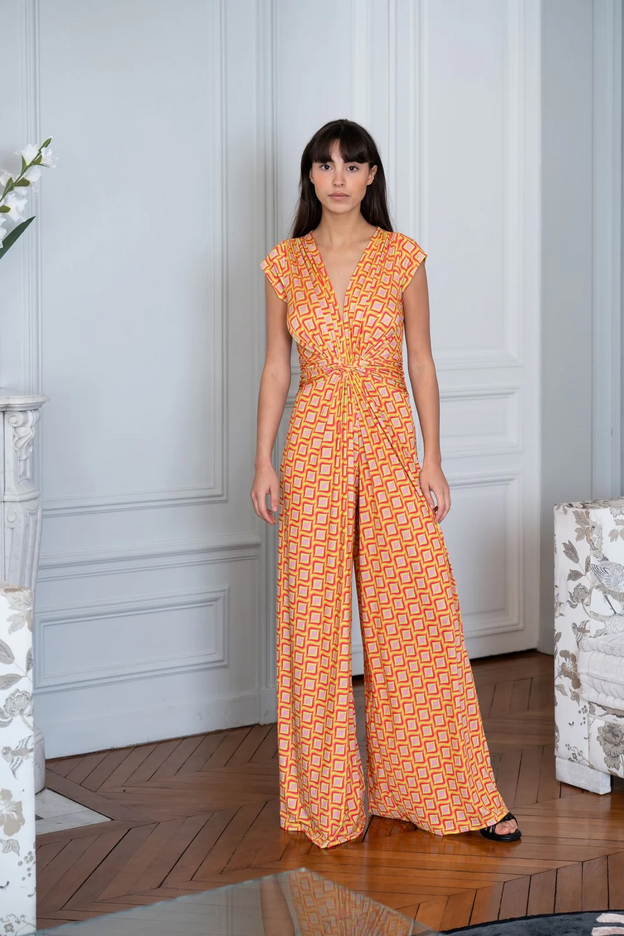 Woman wearing orange jumpsuit with a geometric print
