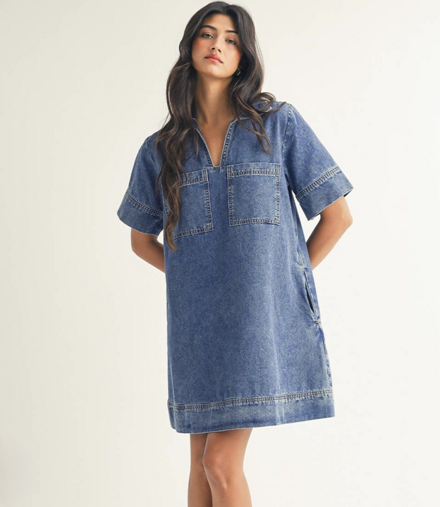 Woman wearing short denim shift dress with patch pockets