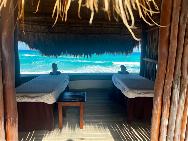 Palapa with two massage tables and a view of the sea through the window