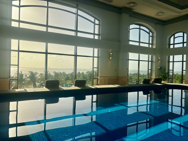 Indoor lap pool in a room with floor to ceiling windows