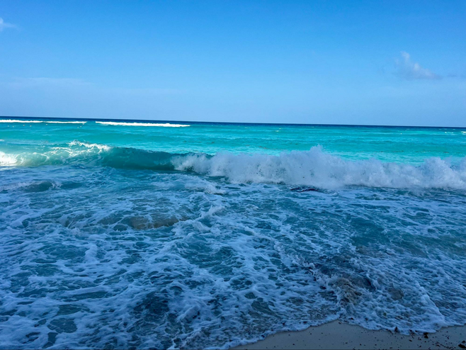 Blue green Caribbean Sea and waves on the beach