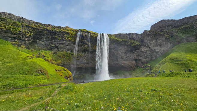 A lush green landscape of the Seljalandsfoss Waterfall