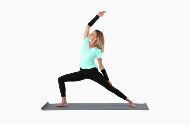 Woman doing yoga on a yoga mat wearing compression sleeves on her forearms.